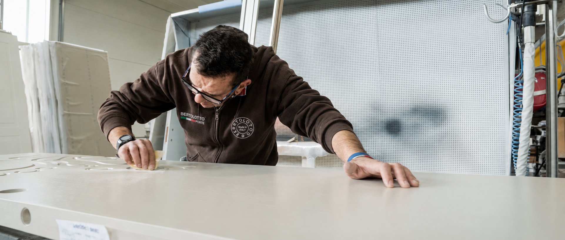 A Bertolotto craftsman working by hand on the surface of a door.